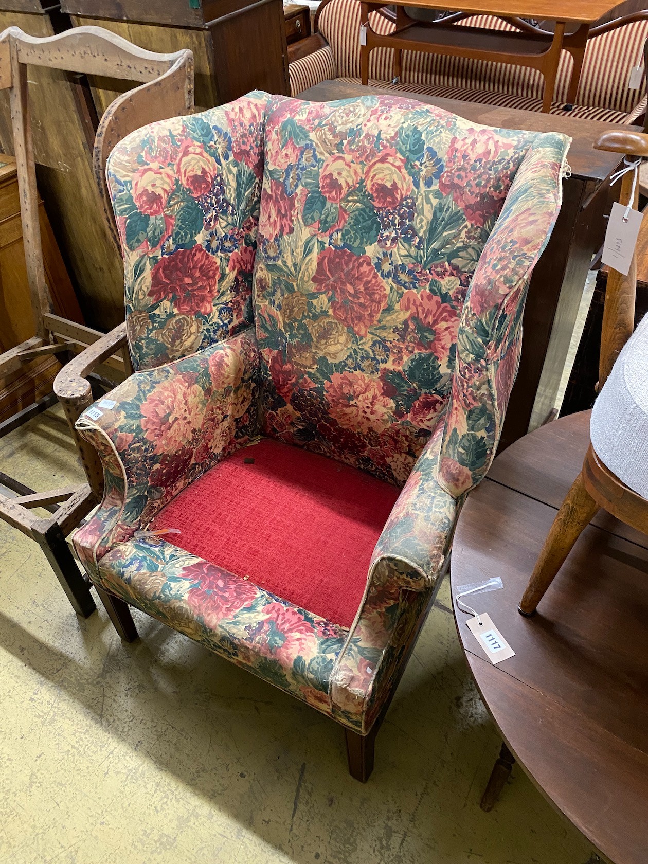 A floral upholstered Georgian style wing armchair (in need of recovering), width 79cm, depth 55cm, height 104cm